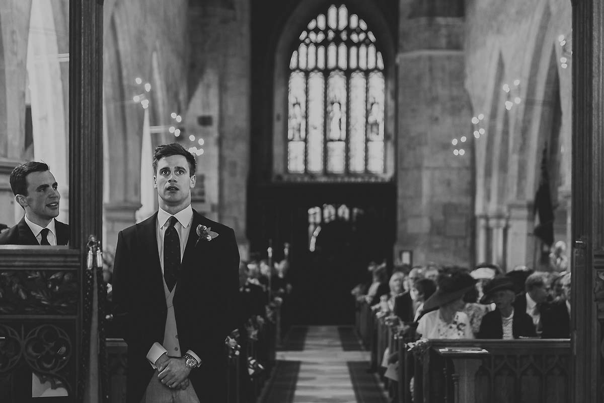 Groom waits for bride by documentary wedding photographer Paul Underhill