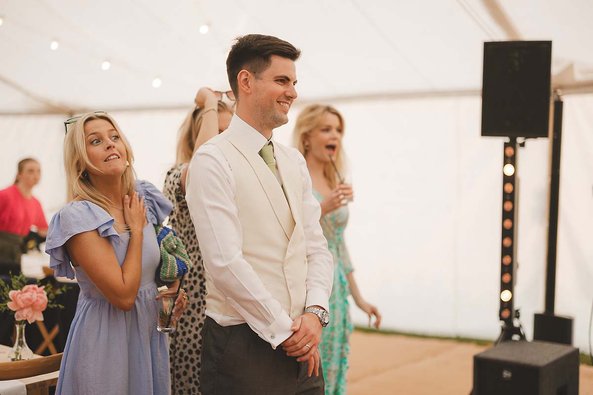 First dance under the marquee lights, surrounded by cheering guests