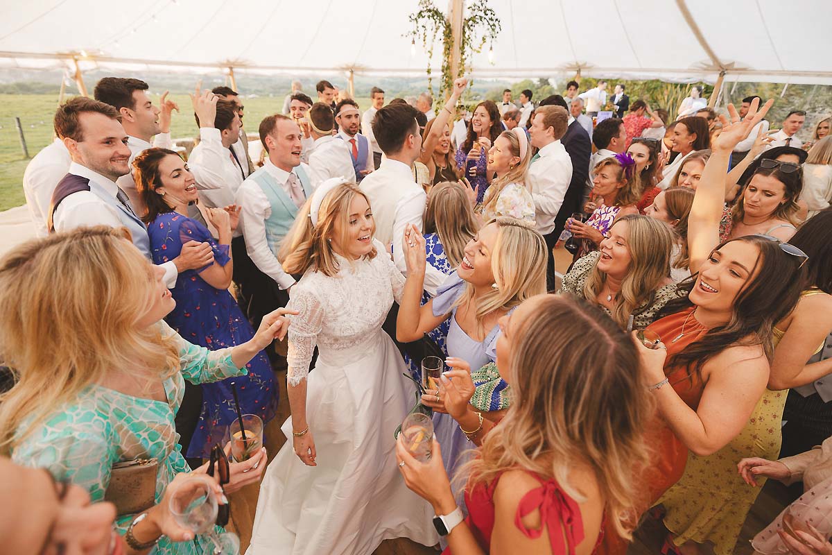 Guests dancing under festoon lights at a Dorset marquee wedding