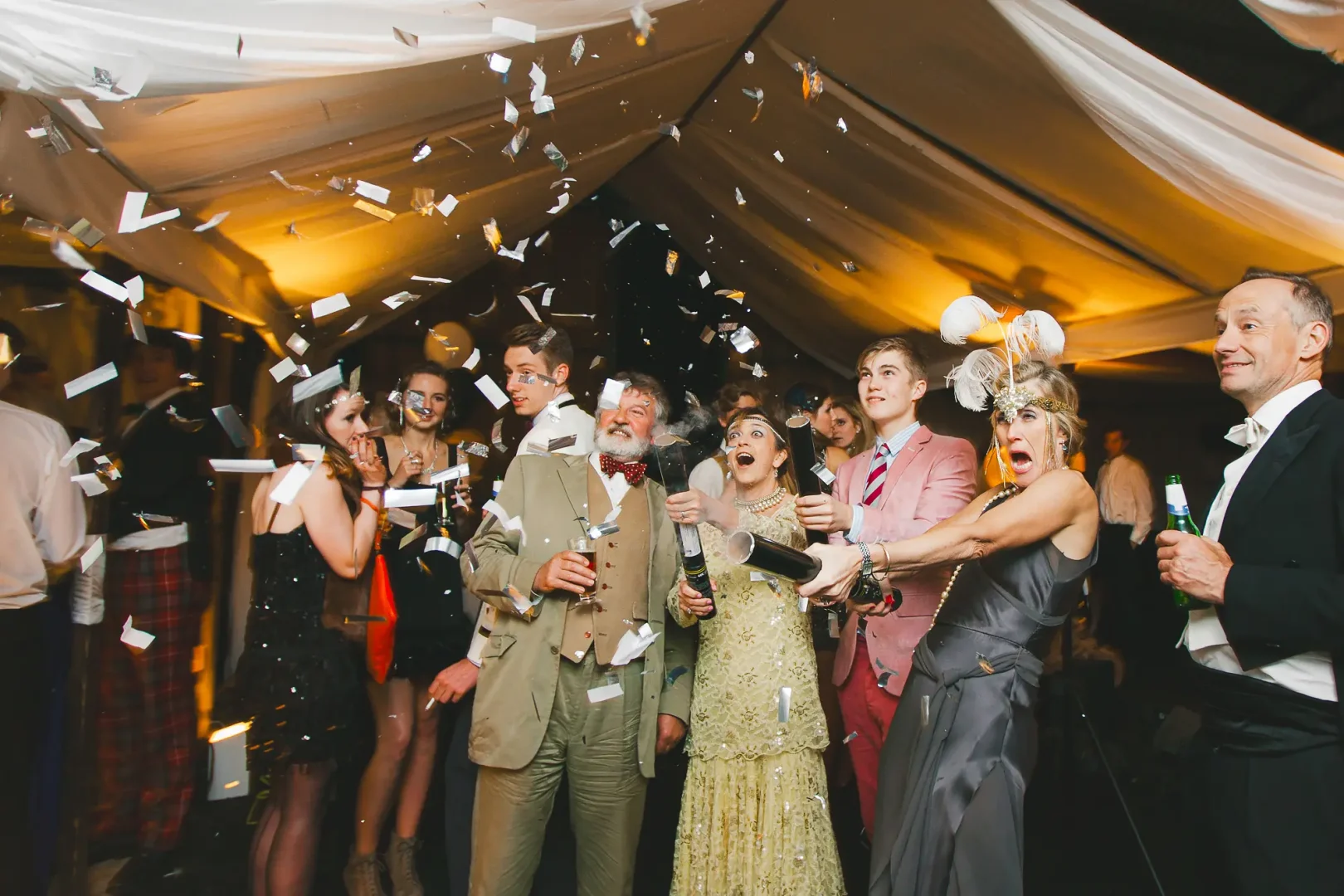Guests celebrating with confetti cannons inside a marquee at a Dorset birthday party