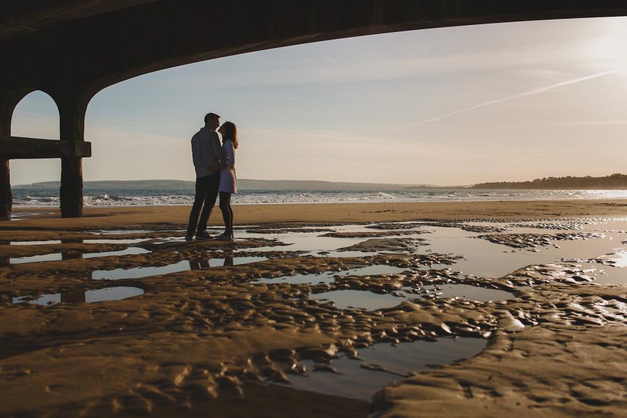 Silhouette of couple beneath Bournemouth Pier during a sunset pre-wedding shoot