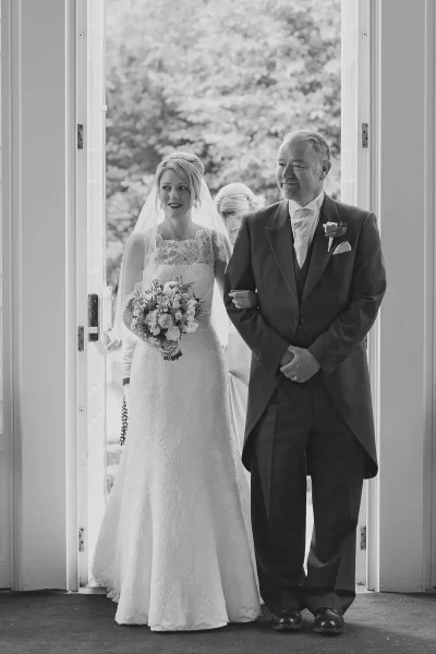Bride and her father standing in the Highcliffe Castle doorway, ready to walk down the aisle