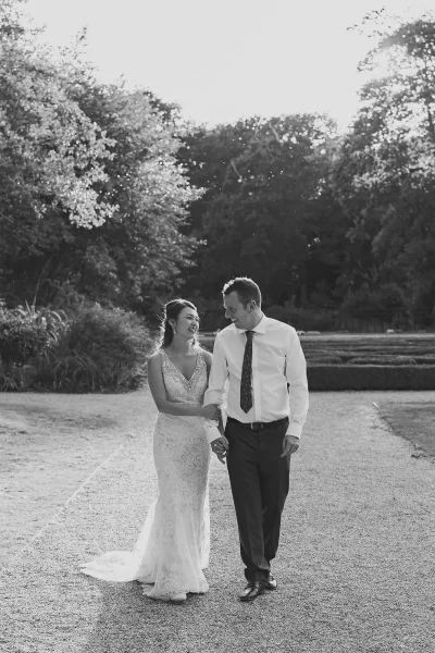 Bride and groom taking an evening stroll through the parterre garden at Highcliffe Castle at dusk