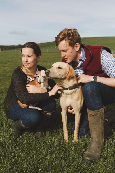 Couple with their dogs during a relaxed countryside pre-wedding shoot in Dorset