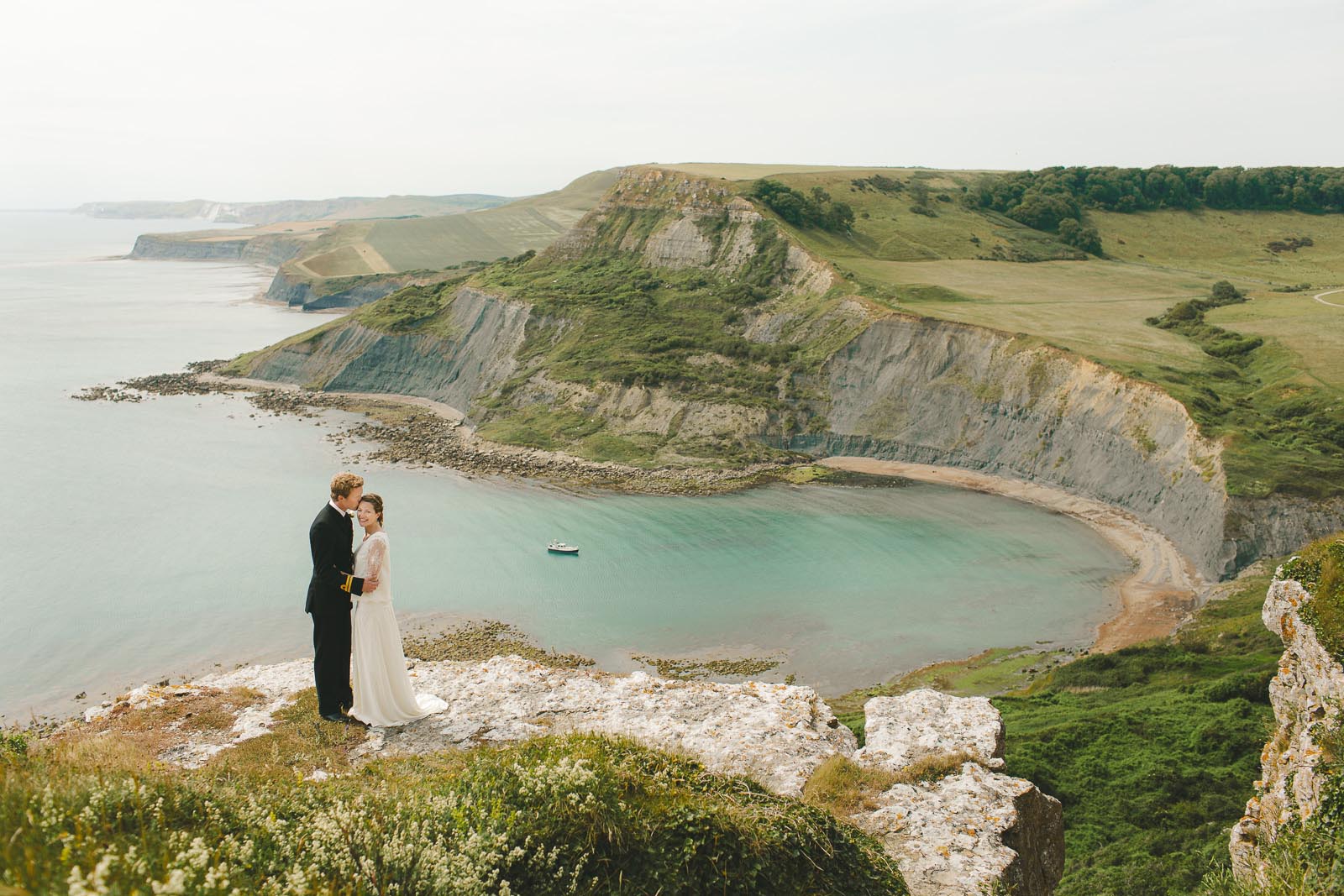 Bride and groom embracing on the clifftops above Chapman's Pool in Dorset