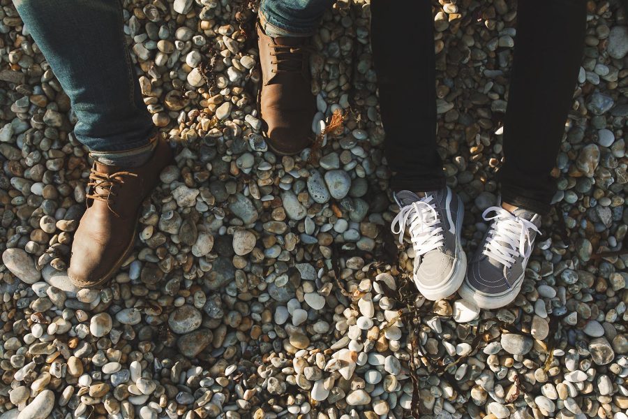 Close up detail of couple’s feet on the pebble beach during a pre-wedding shoot at Durdle Door in Dorset