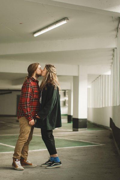 Editorial style portrait of couple sharing a kiss during a relaxed shoot