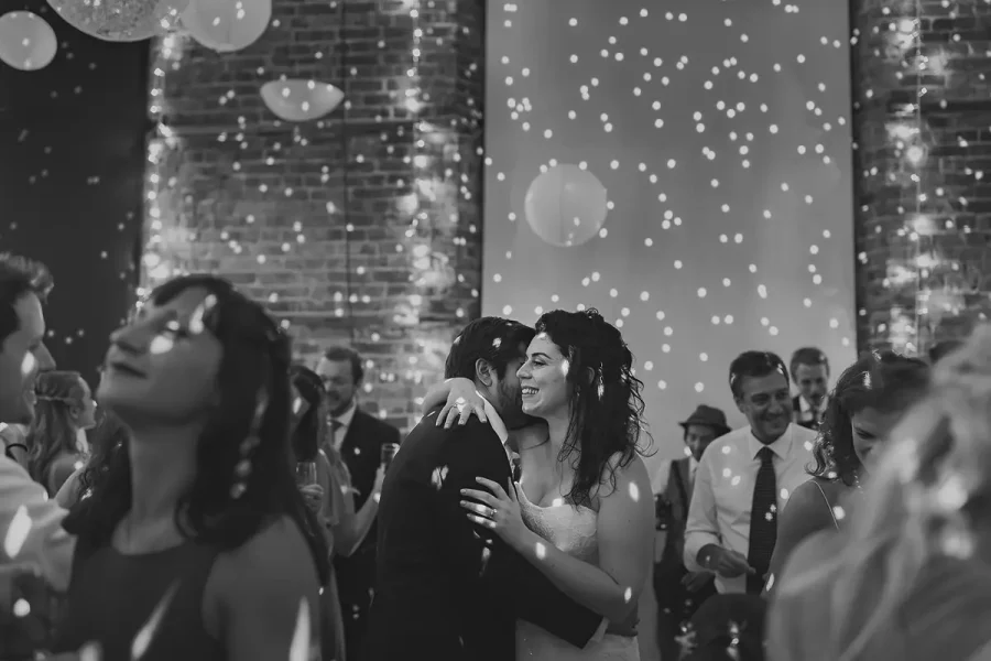 Bride and groom dancing in the Great Hall at Highcliffe Castle with bubbles drifting through fairy light