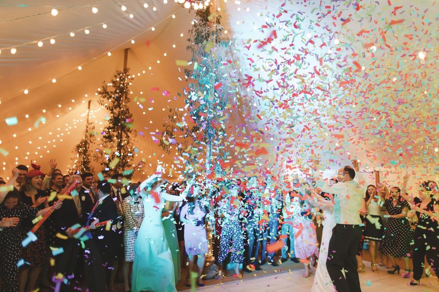 Bride and groom's first dance as colourful confetti cannons explode around them inside the fairy-lit marquee at Smedmore House