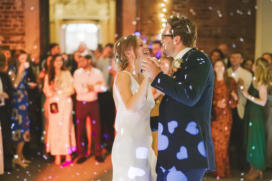 Bride and groom laughing during their first dance at Highcliffe Castle