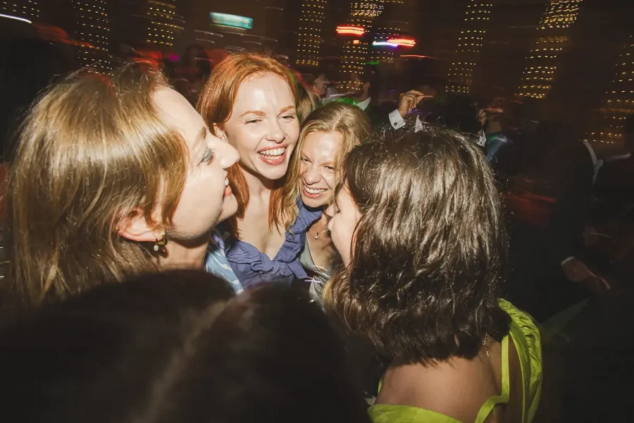 Group of friends laughing and dancing together in the Great Hall at Highcliffe Castle late in the evening