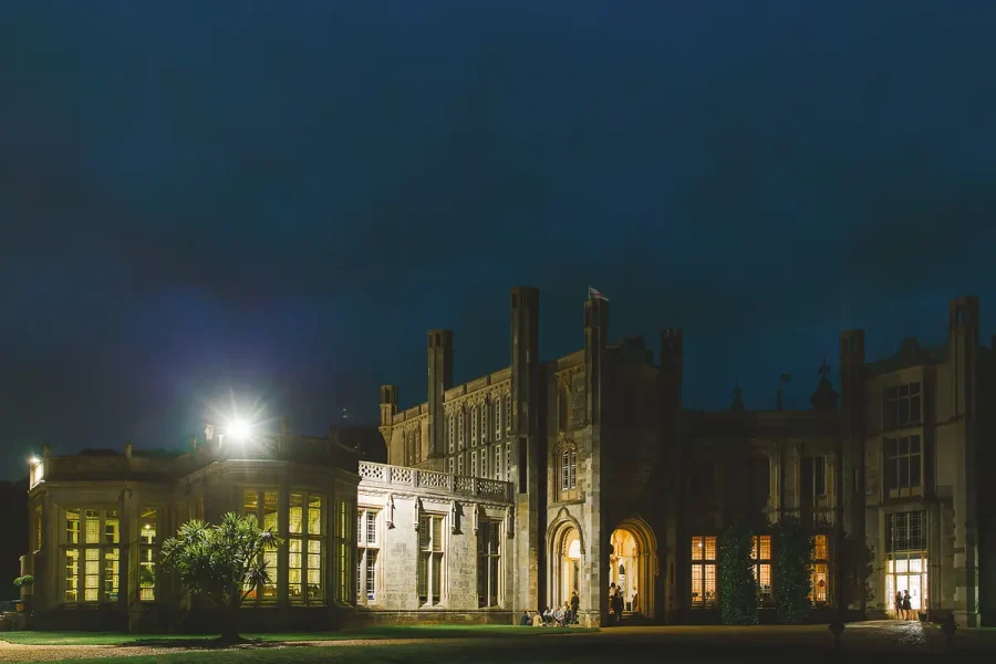 Highcliffe Castle fully illuminated at night, showing the Gothic facade and Wintergarden during a wedding evening