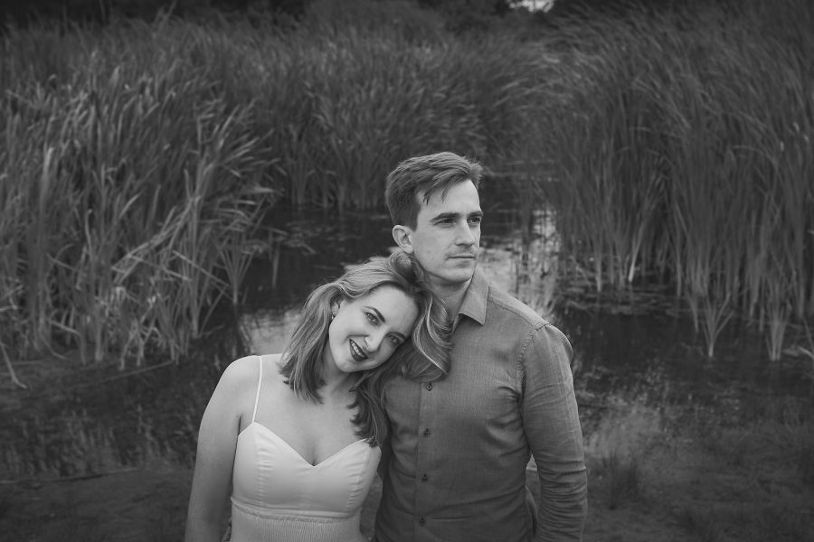 Relaxed portrait of couple standing beside reeds by the river