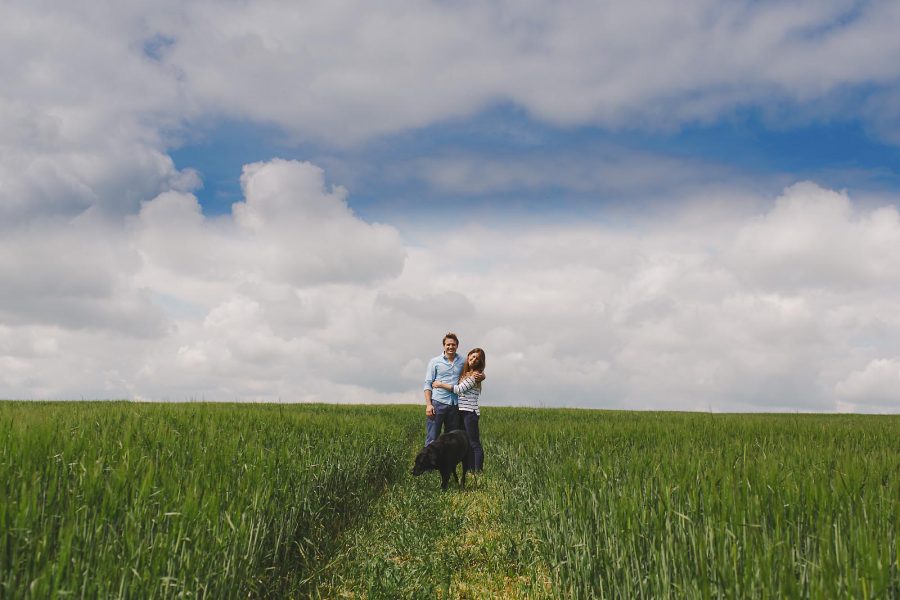 Couple with their dog during a relaxed rural Dorset pre-wedding shoot on a private farm