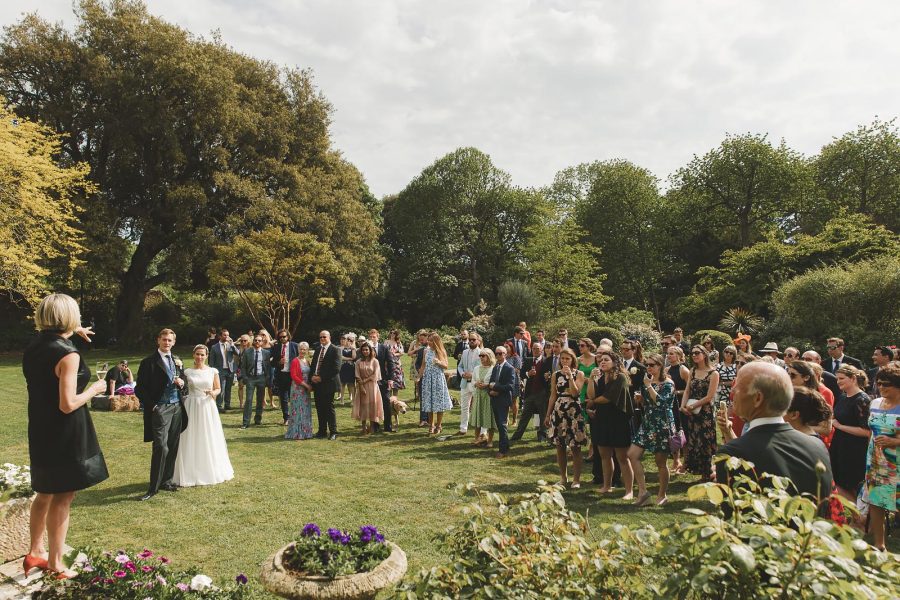 Wedding guests mingling on the lawn for a drinks reception in the walled gardens at Smedmore House, Dorset