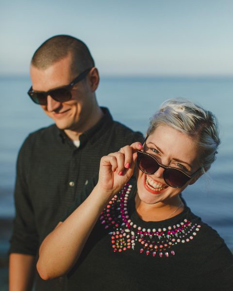 Couple laughing by the sea during a pre-wedding shoot at Studland Bay in Dorset