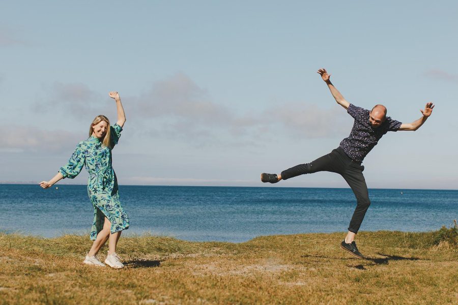 Fun couples shoot at Studland in Dorset with couple jumping by the sea