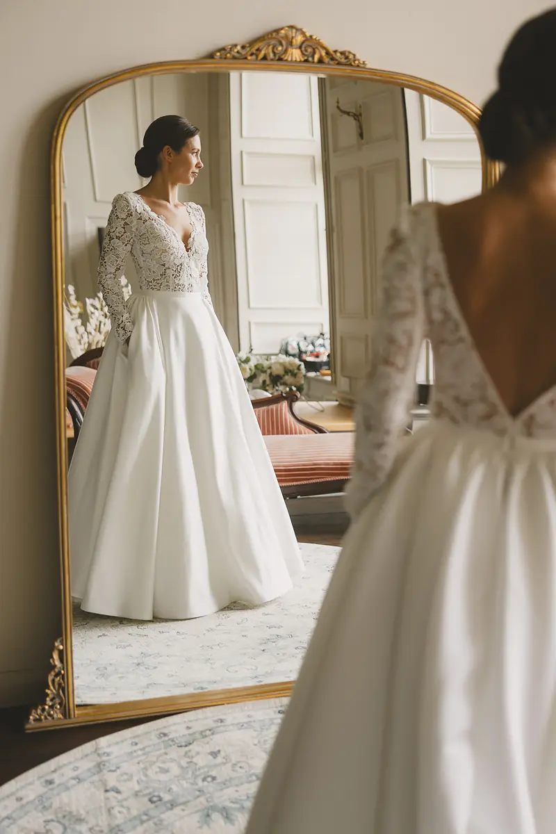 Bride reflected in a mirror during wedding preparations at a country house