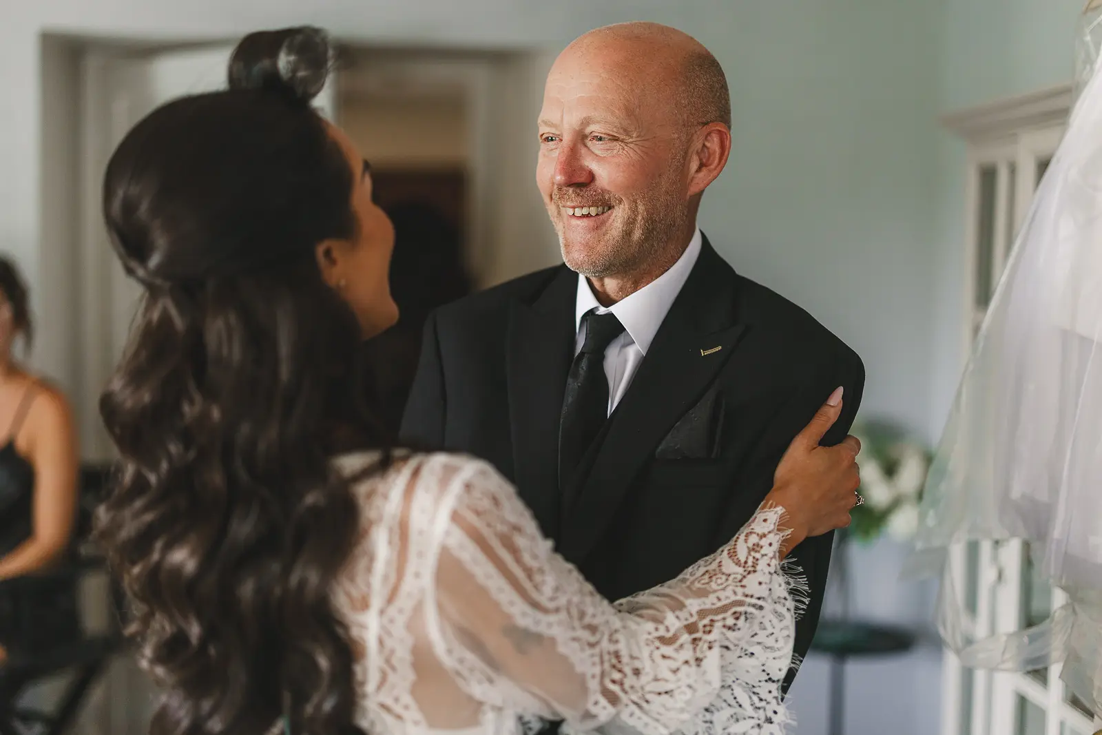 Father sees the bride in her wedding dress for the first time in the getting-ready room, an emotional first look moment