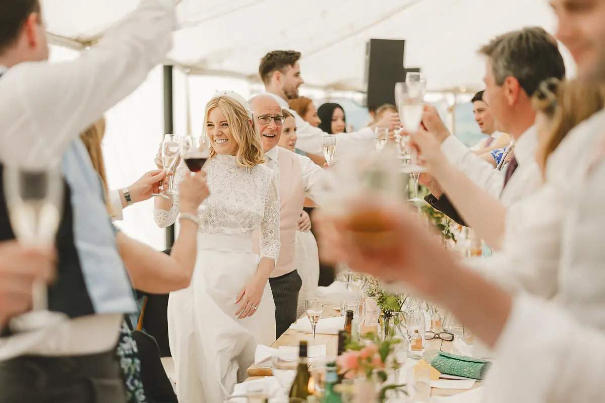 Bride laughing during a toast surrounded by guests at a Dorset wedding reception