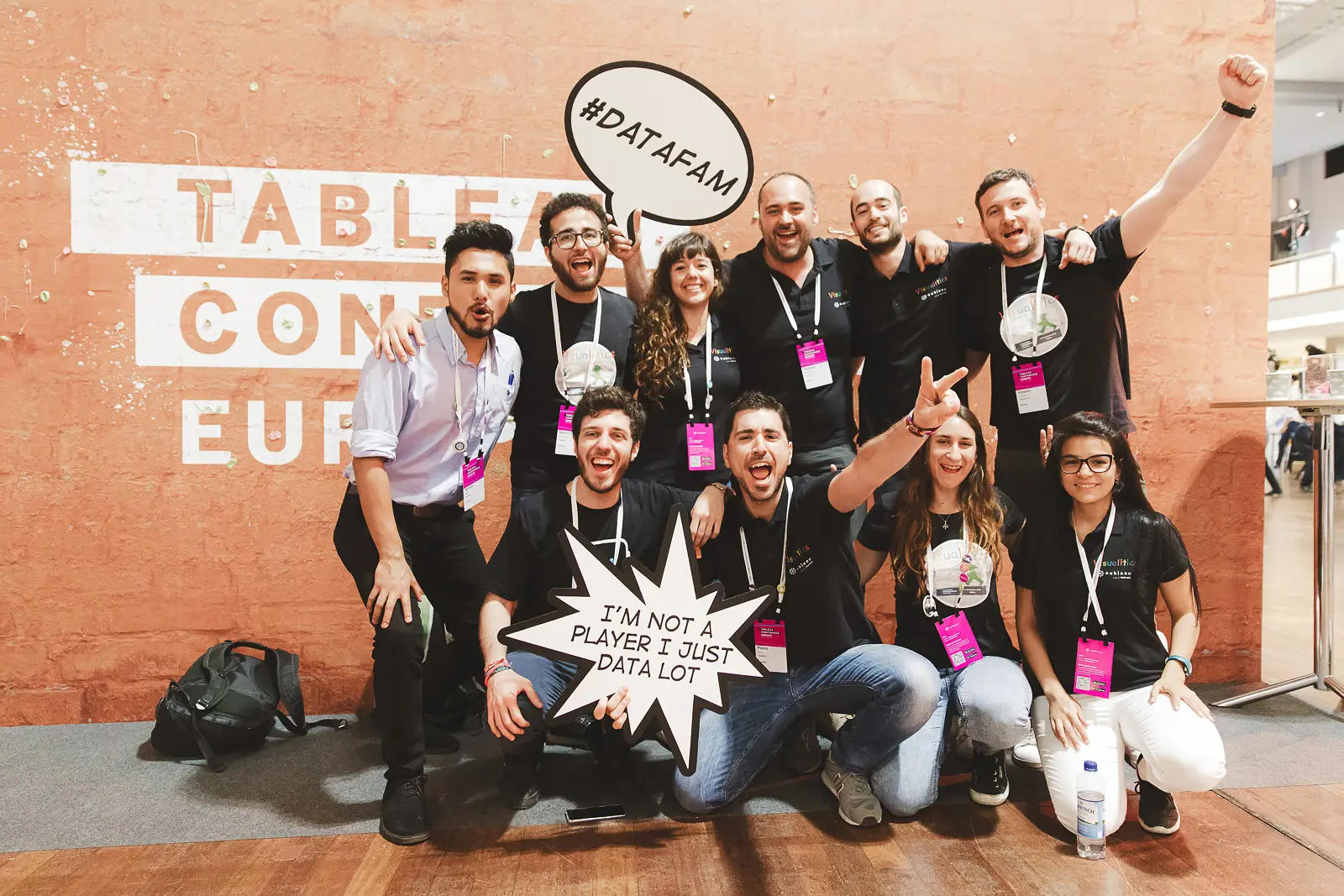 Conference team group photo in front of a branded event backdrop