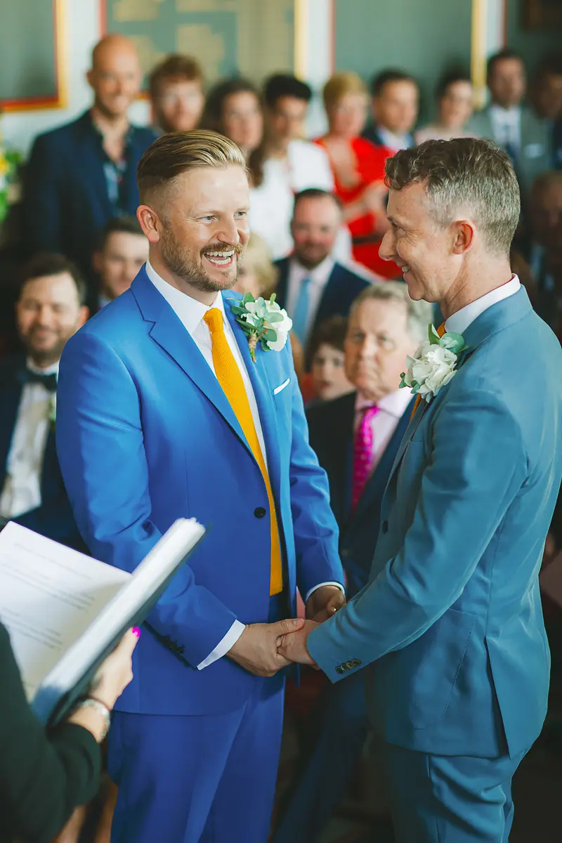 Grooms smiling during an emotional indoor wedding ceremony at a Dorset wedding venue
