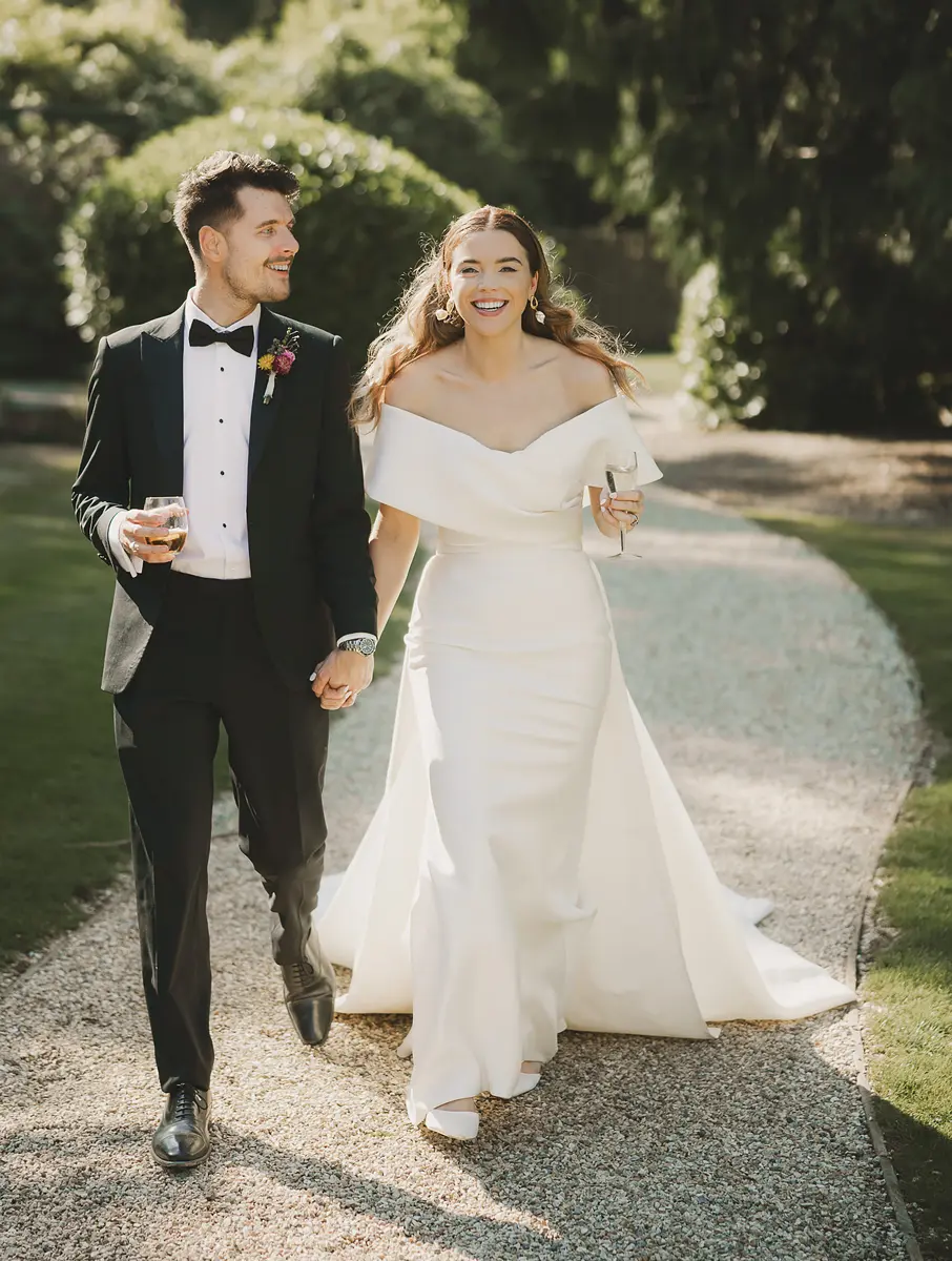 Bride and groom walking hand in hand through the gardens at a Dorset wedding venue