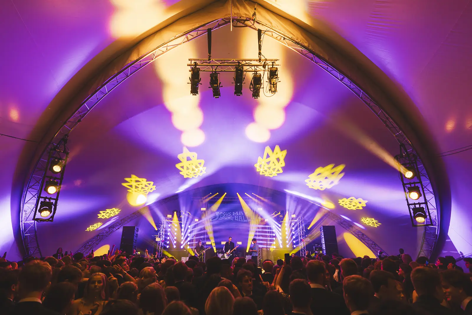 Crowd in front of the main stage at a large black tie summer ball, photographed during a commercial event commission at Jesus College Cambridge