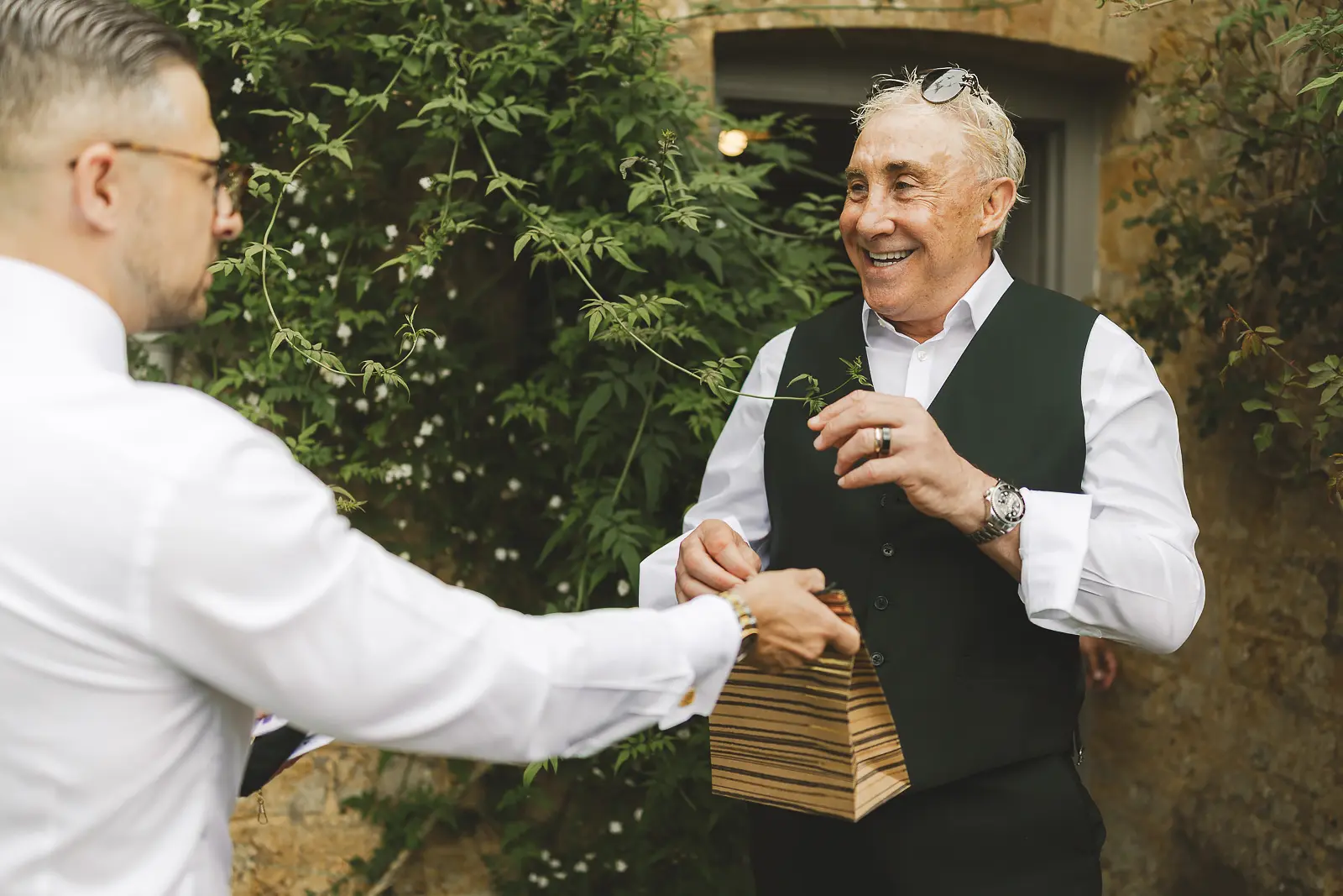 Groom receiving a wrapped gift from his father before the wedding ceremony, an emotional morning moment