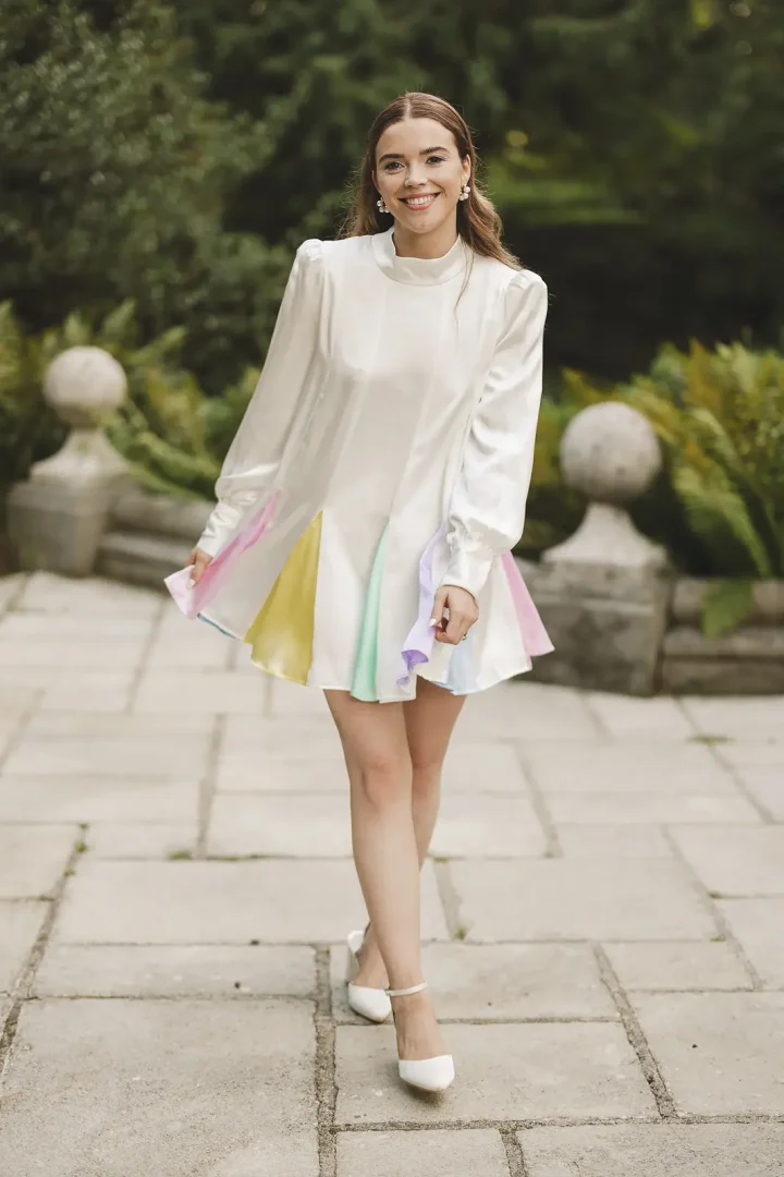 Bride walking in Oliver Rubin Dora reception dress at Larmer Tree Gardens