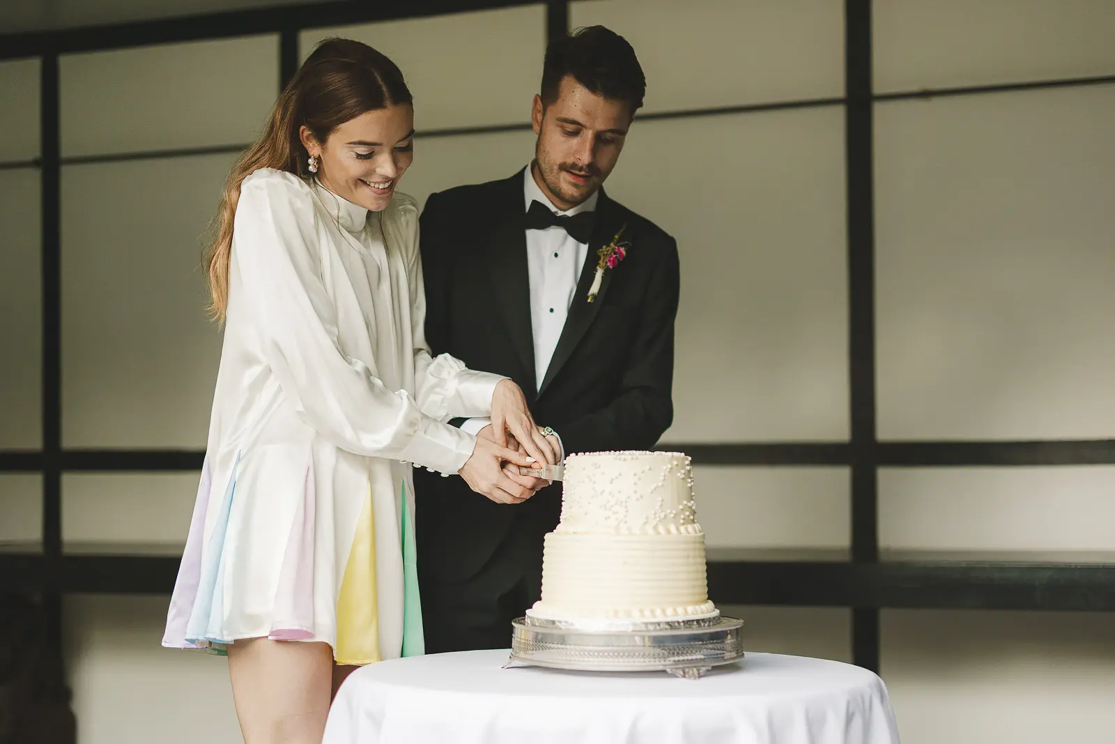 Bride and groom cutting wedding cake at Larmer Tree Gardens with bride in Oliver Rubin Dora dress