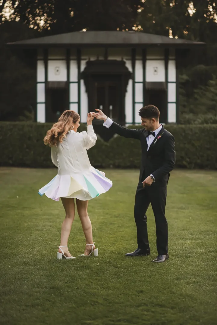 Bride twirling in Oliver Rubin Dora reception dress with groom at Larmer Tree Gardens wedding