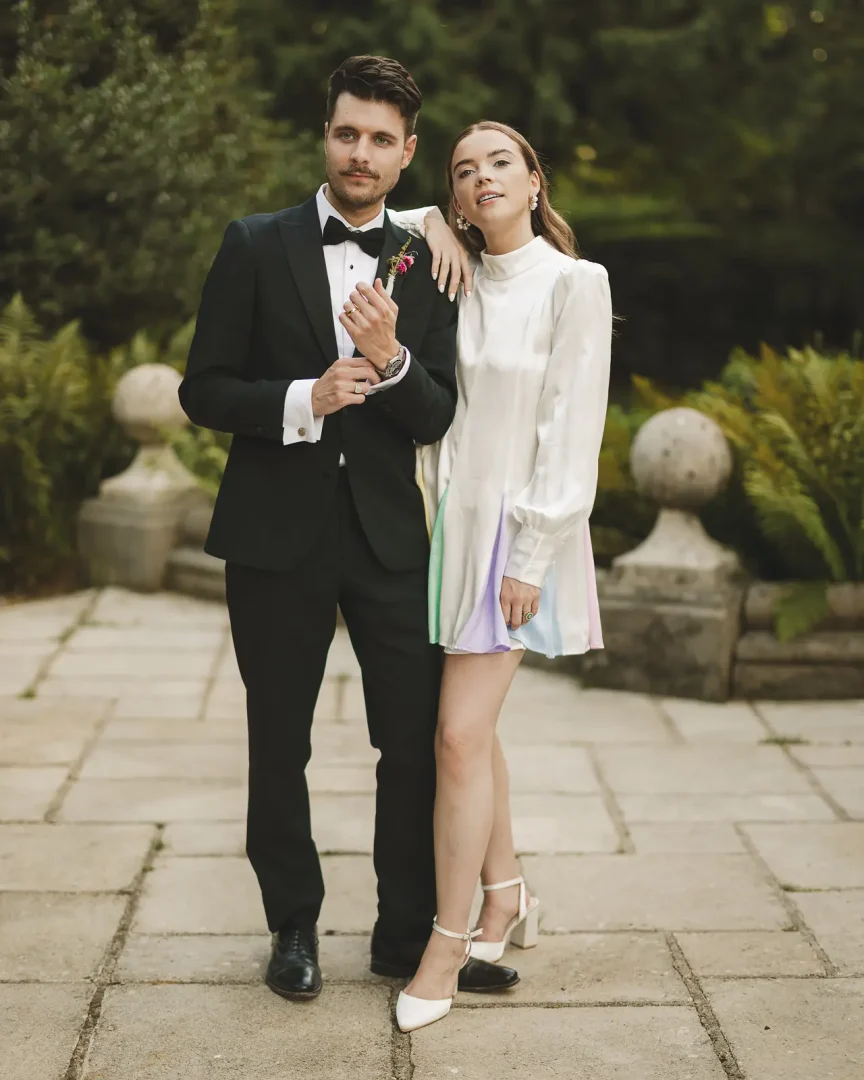 Bride wearing Oliver Rubin Dora reception dress with groom during Larmer Tree Gardens wedding