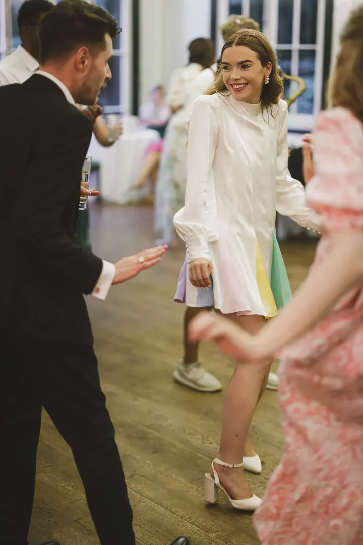 Bride dancing with guests during evening celebrations at Larmer Tree Gardens wedding