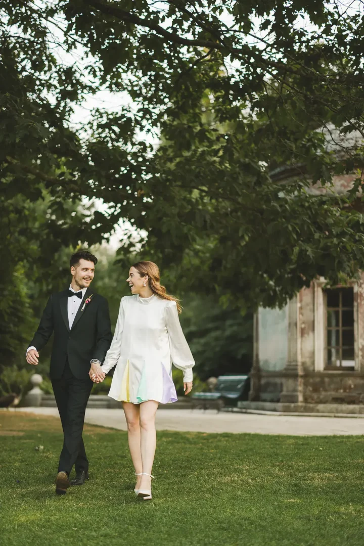 Bride and groom walking through gardens at Larmer Tree Gardens wedding