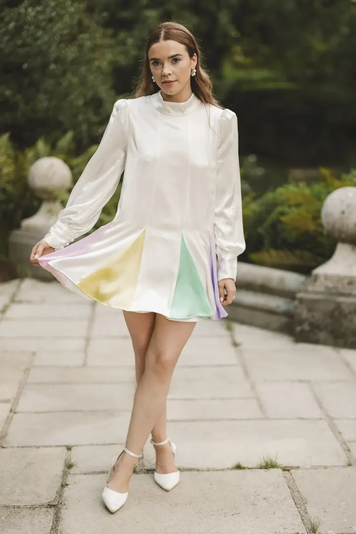 Bride wearing Oliver Rubin Dora reception dress walking through Larmer Tree Gardens
