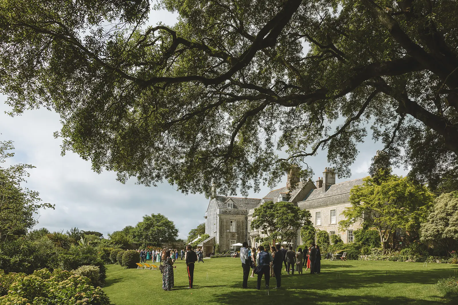Wedding guests in the gardens at Smedmore House during drinks reception Dorset