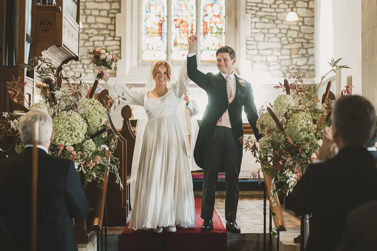 Bride and groom celebrate during church wedding in rural Dorset