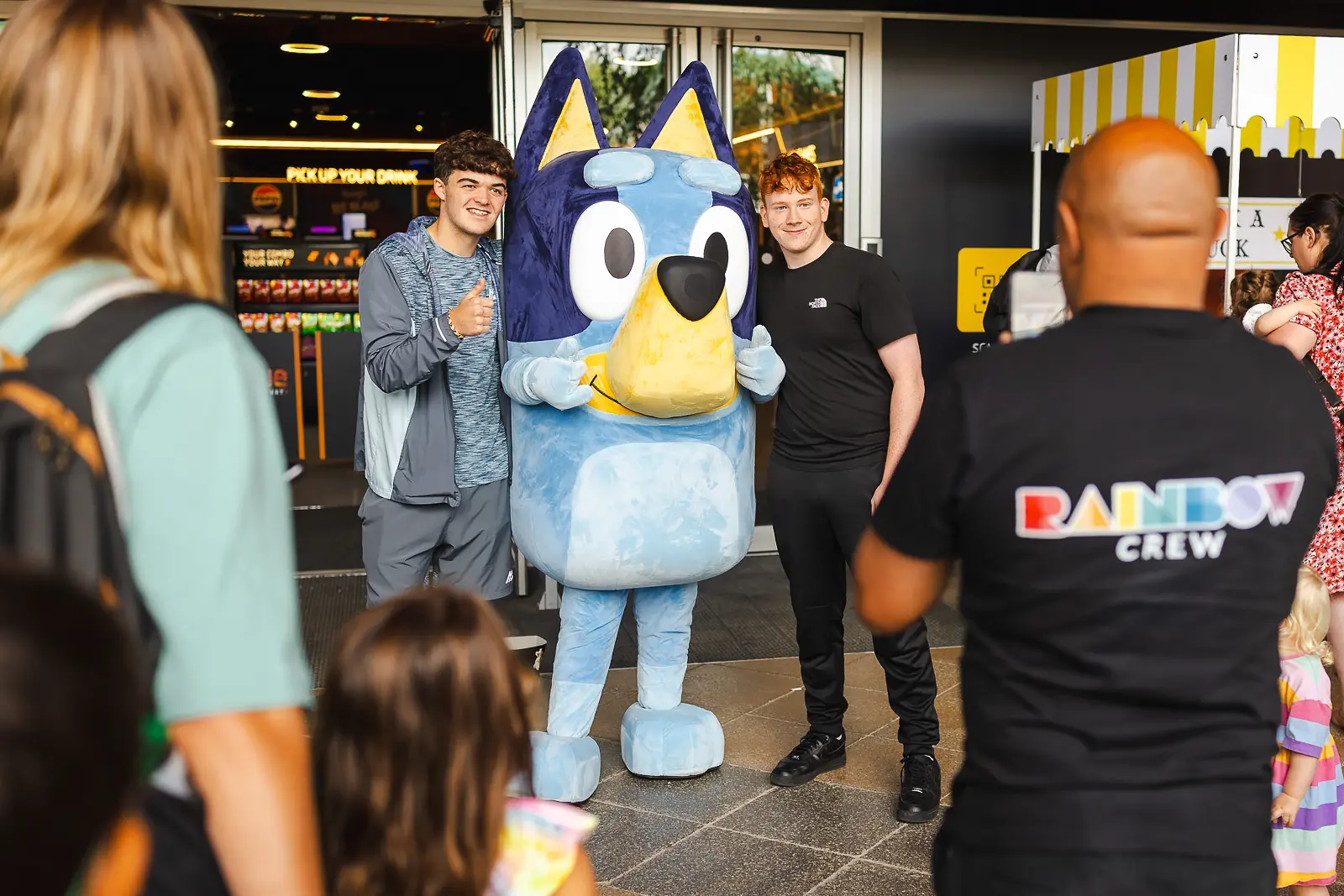Two teenage boys posing with a costumed character at a brand activation event in Dorset, with an event photographer in the foreground