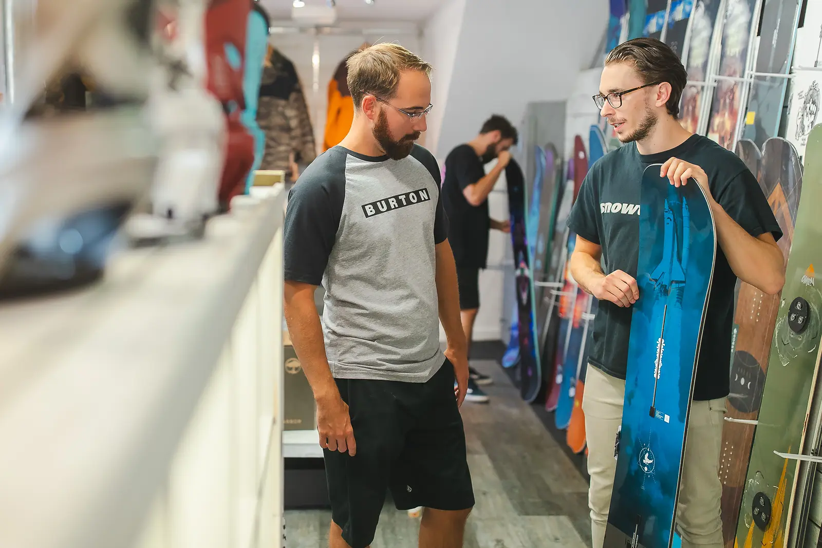 Lifestyle commercial photography in Bournemouth showing a snowboard shop staff member advising a customer in store