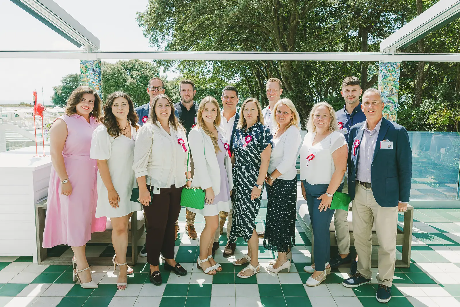 Group of smartly dressed professionals wearing charity badges at a summer rooftop terrace event in Dorset