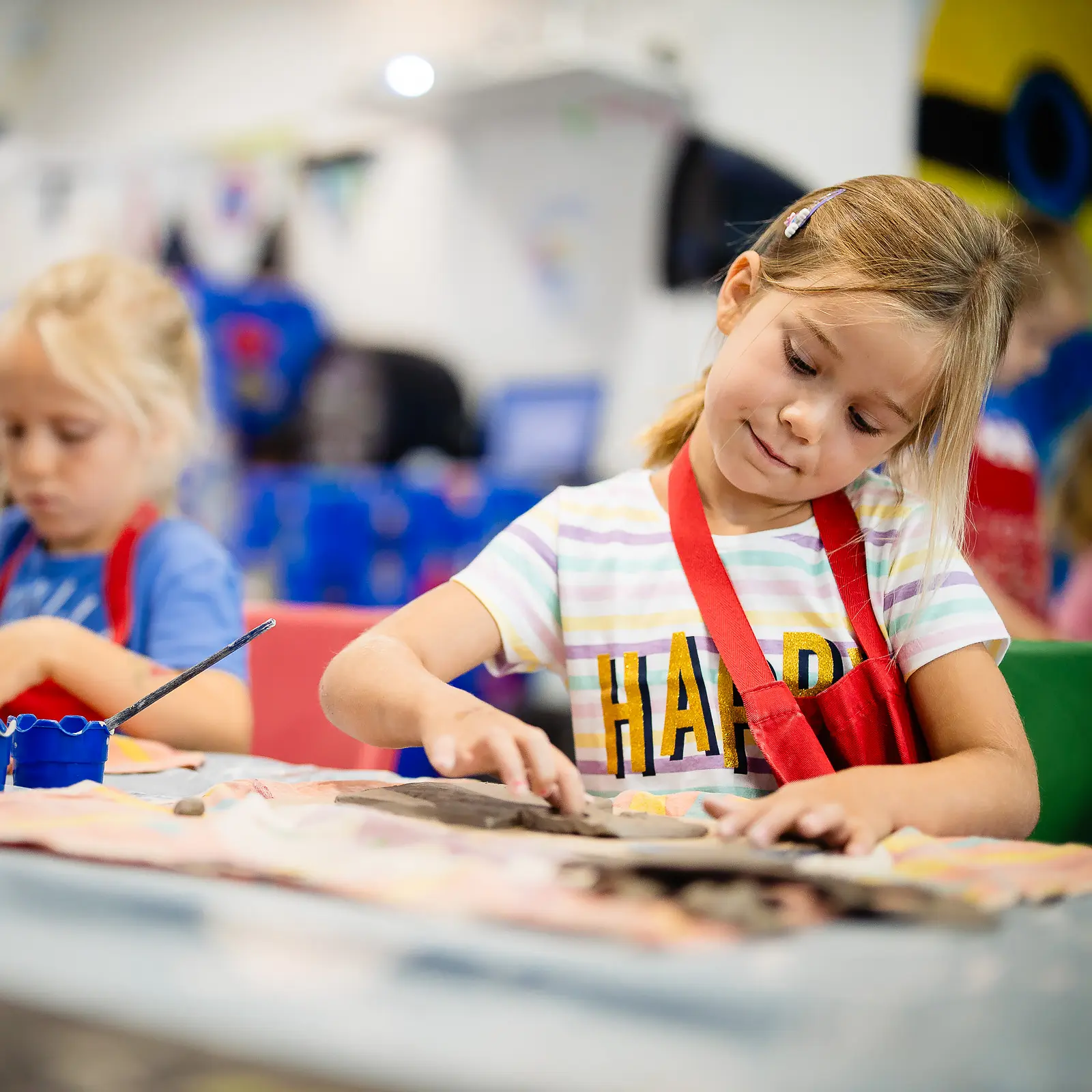 Young girl concentrating on a clay craft activity at a Creative Kids workshop in Bournemouth