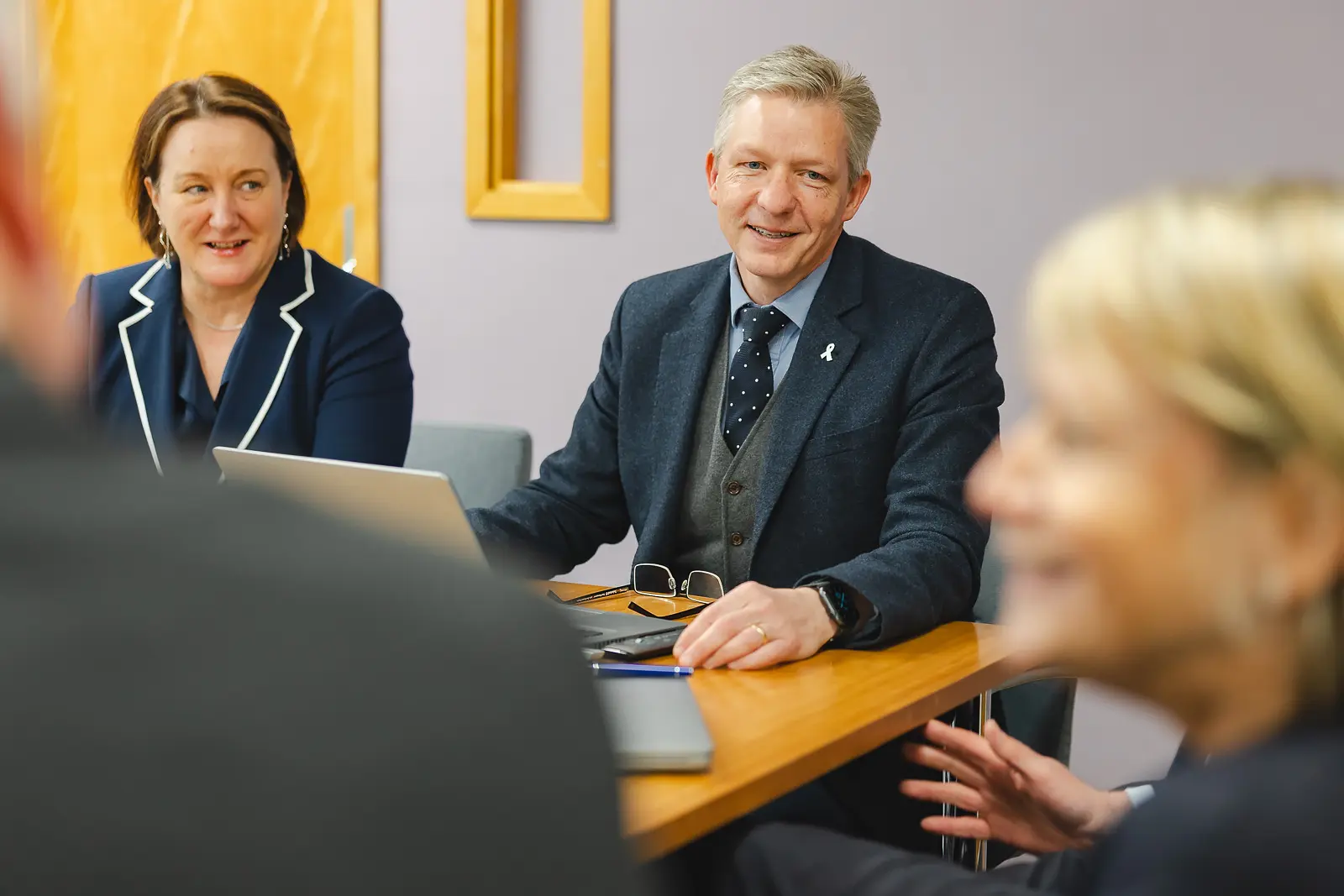 Senior leaders in relaxed discussion around a meeting table at County Hall Dorchester, natural commercial lifestyle photography