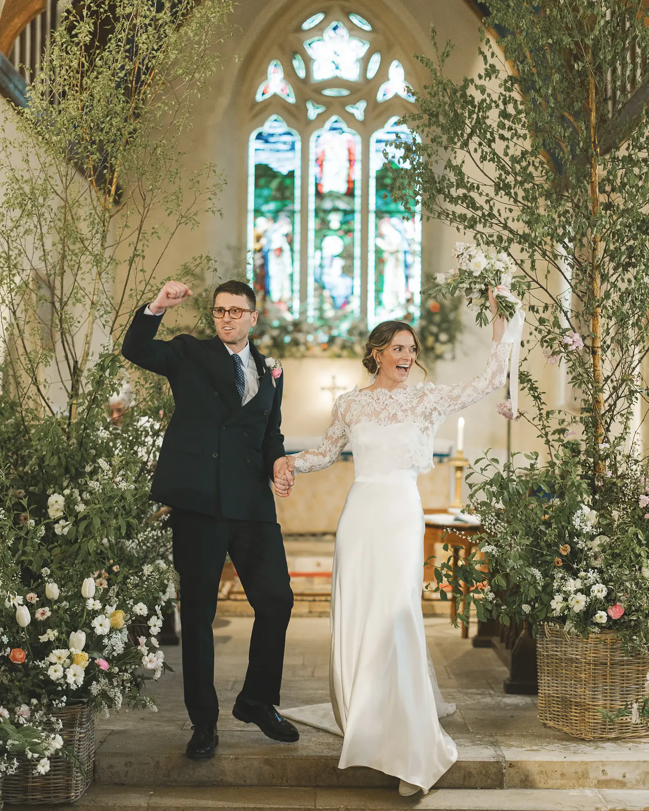 Newly married couple celebrating at the end of their church ceremony, photographed by Dorset wedding photographer Paul Underhill