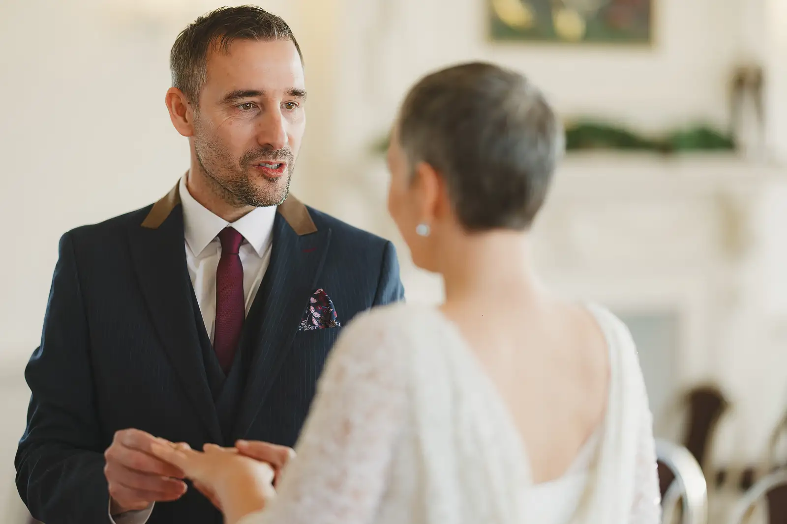 Groom speaking his wedding vows and holding bride's hands during intimate ceremony at Poole Guildhall Registry Office