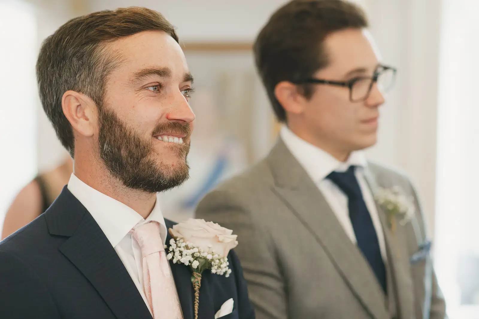 Groom smiling as his bride approaches during wedding ceremony at Poole Guildhall Registry Office