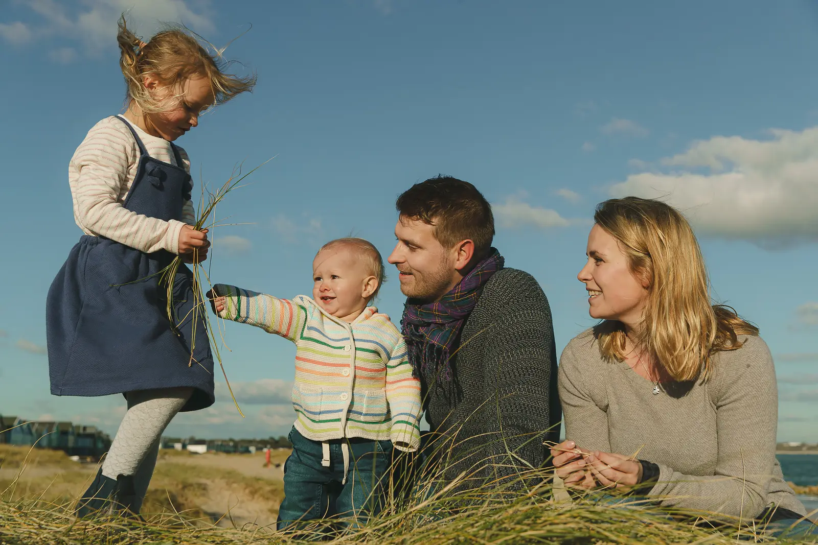 Documentary family photograph at Hengistbury Head, with parents and children relaxing in the dunes.