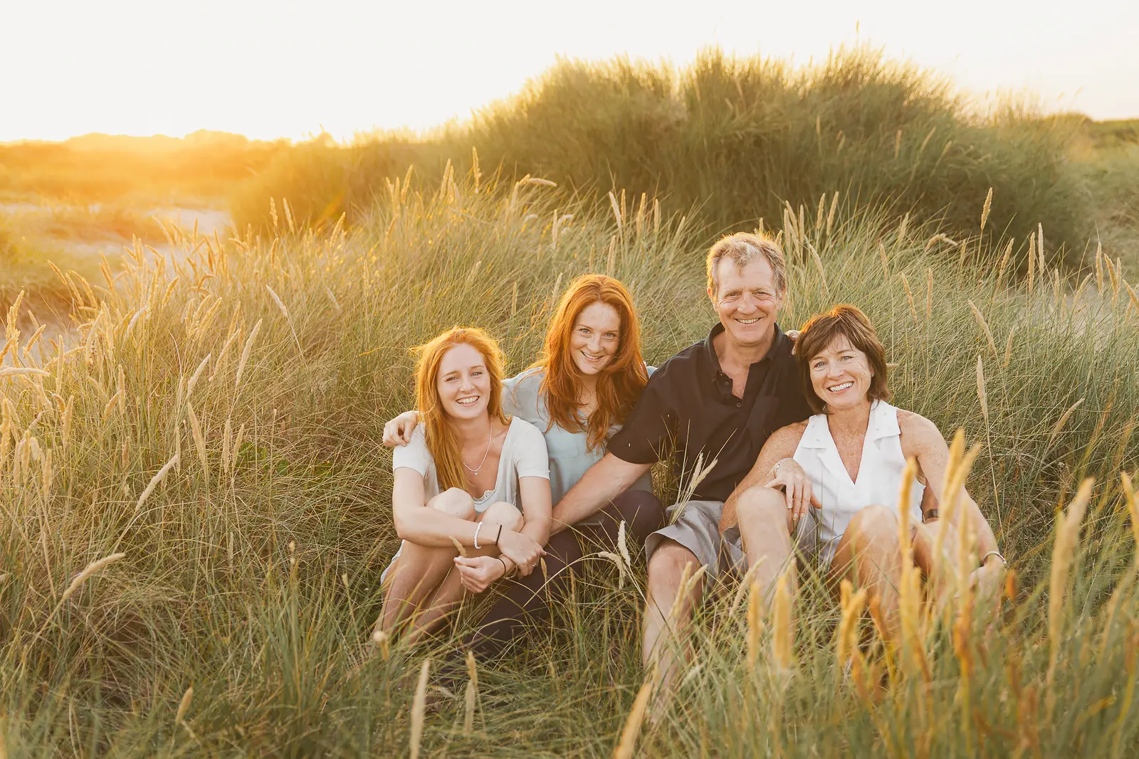 Relaxed family portrait photographed in the dunes at Hengistbury Head near Bournemouth.