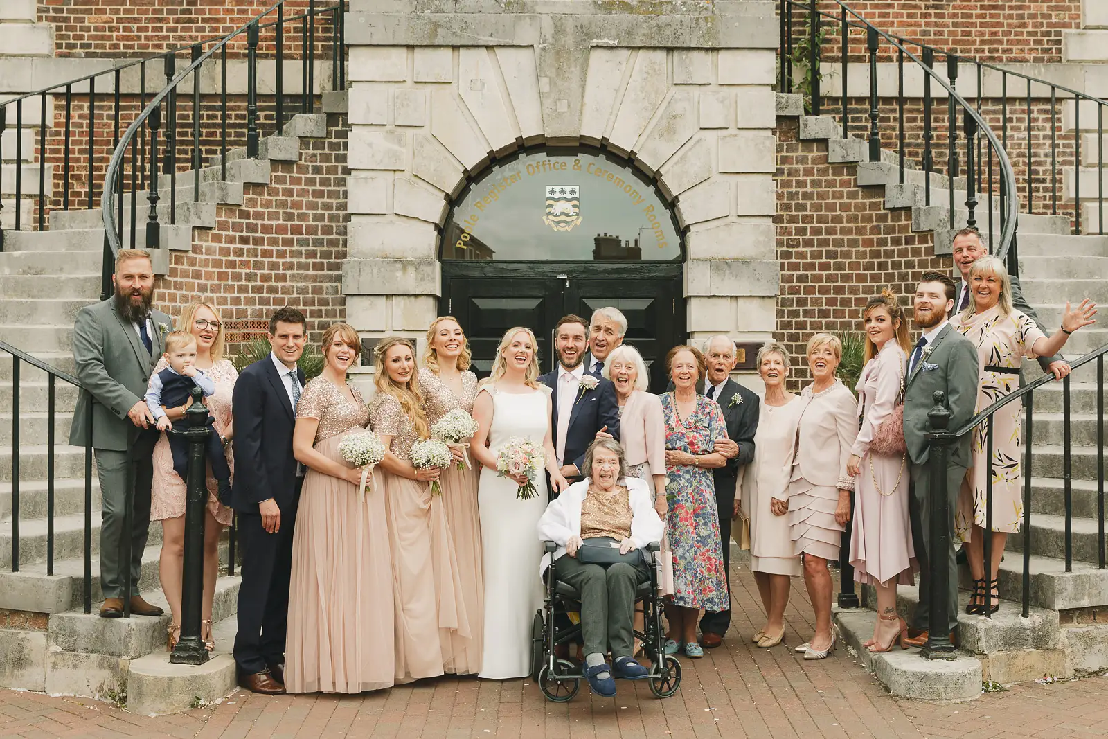 Wedding party and family group photograph on the steps of Poole Guildhall Registry Office after the ceremony