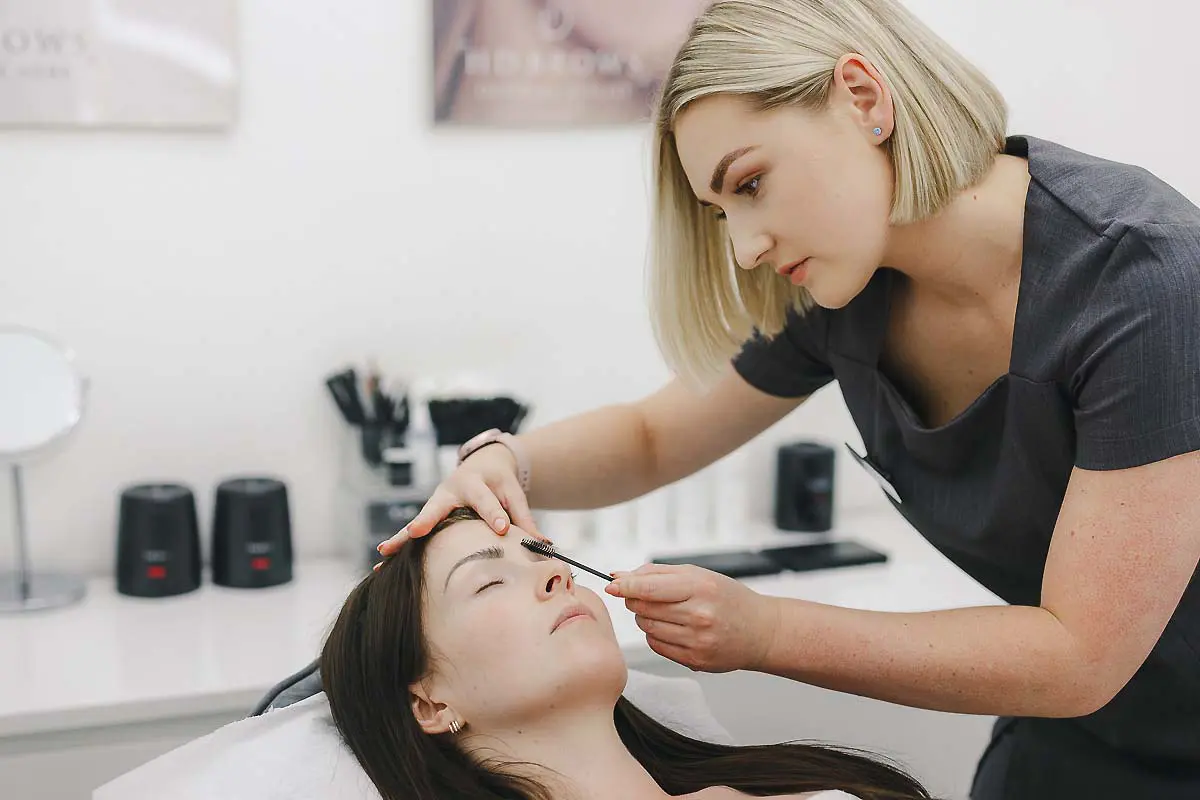 Beauty therapist carrying out an eyebrow treatment during a Bournemouth branding photography shoot.